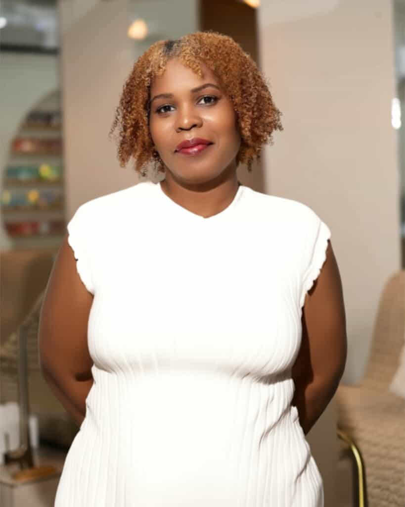 Beautiful woman with curly hair in a modern salon setting, showcasing professional hair styling and beauty services at Haven Beauty House.