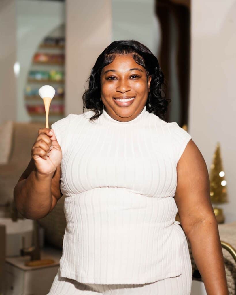 Beautiful woman smiling with a makeup sponge, showcasing beauty and self-care at Haven Beauty House.