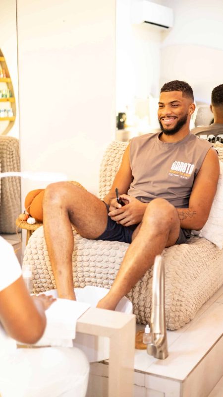 A young man enjoying a foot spa treatment at Haven Beauty House, showcasing professional nail and foot care services in a comfortable, modern salon setting emphasizing relaxation and personal grooming.