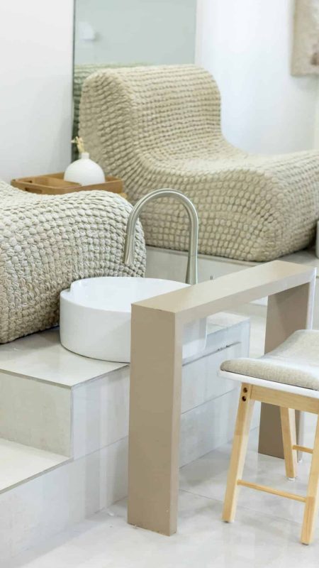 Relaxing nail salon stations with plush foot baths, comfortable seating, and modern decor, perfect for skincare and manicure treatments in a serene spa environment.